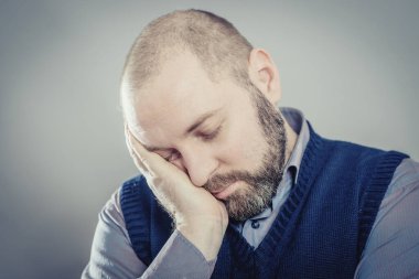 Genç adam uyumak istiyor. Kafasını ellerine koy.