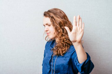 Kıvırcık kızlar durur. Gri arkaplan.