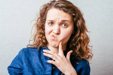 Genç bir kadın hayal kuruyor, hayal kuruyor, el pençe divan bir yere bakıyor.