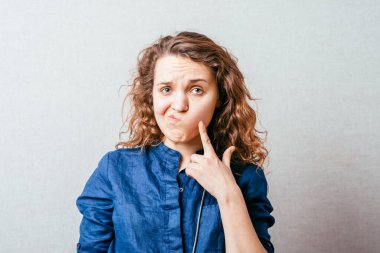 Genç bir kadın hayal kuruyor, hayal kuruyor, el pençe divan bir yere bakıyor.