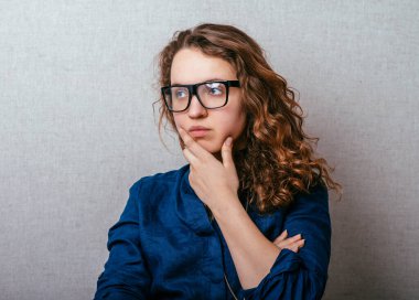 Genç bir kadın hayal kuruyor, hayal kuruyor, el pençe divan bir yere bakıyor.