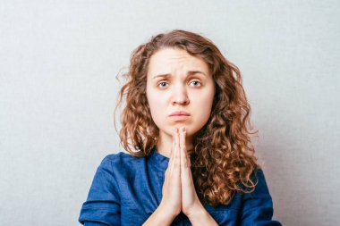 Dua eden bir kadın. Gri arkaplan