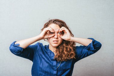 Güzel genç bir kadın, geniş gözleri ve hayali dürbünü olan bir şey arıyor.