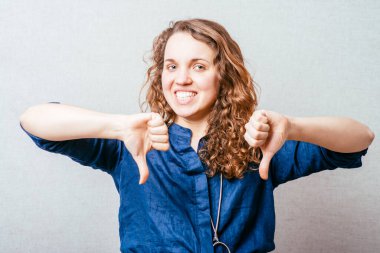 Bir kadın kötü bir hareket sergiliyor. Gri arkaplan