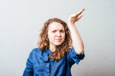 Bir kadın şaşkınlıkla elini kaldırdı, sordu. Gri arkaplan