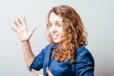 Bir kadın şaşkınlıkla elini kaldırdı, sordu. Gri arkaplan