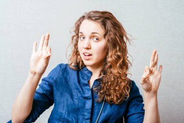 Bir kadın iyi bir jest gösterir. Gri arkaplan