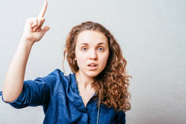 Kadın işaret parmağını yukarı doğru gösterir