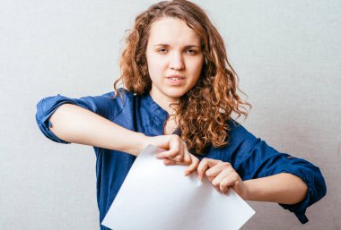 Stüdyonun arka planında kağıt yırtan kadın.