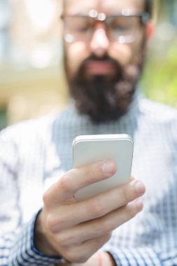 Akıllı telefonu olan sakallı bir adam.