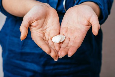 Deniz kabuğu tutan bir kız