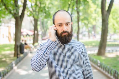 Genç adam cep telefonuyla konuşuyor.