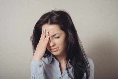 Kadın eli kafasında, hatırladı, unuttu. Jest yap. Gri bir arkaplanda.