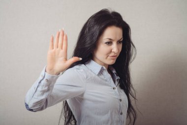 Duran bir kadın, olamaz, bir mola. Gri bir arkaplanda.