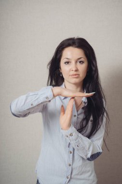 Duran bir kadın, olamaz, bir mola. Gri bir arkaplanda.