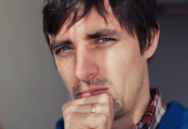 Delikanlı yumruğu ağzında düşünüyor.