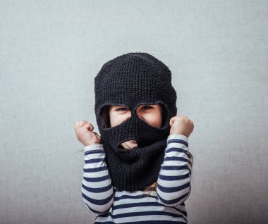 Küçük kız kar maskesi ya da kar maskesi takıyor.