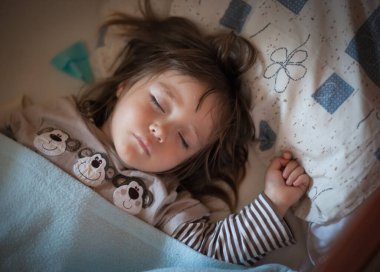Küçük kız yatağında iyi uyuyor.