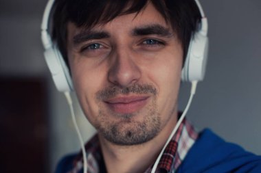 Müzik dinleyen genç bir adamın portresi.