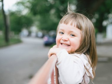 Parkta gülümseyen sevimli küçük kız.