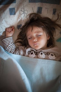 Küçük kız yatağında iyi uyuyor.