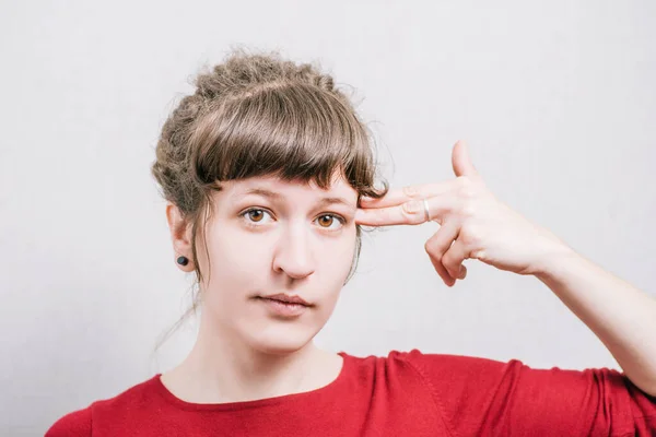 Vrouw Met Een Zelfmoordgebaar Hand Vorm Pistool Een Grijze Achtergrond — Stockfoto