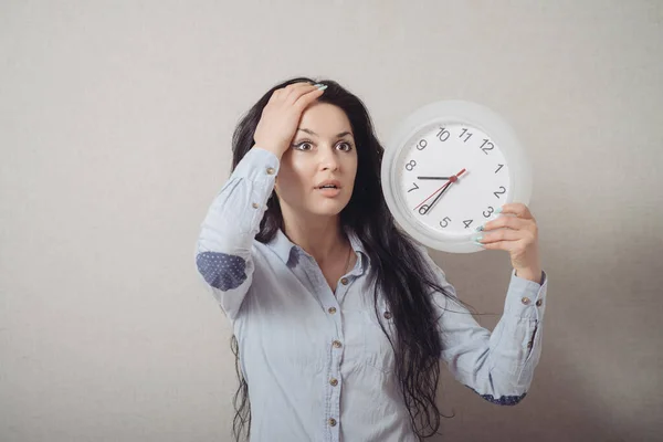 Een Vrouw Met Een Wandklok Laat Een Grijze Achtergrond — Stockfoto