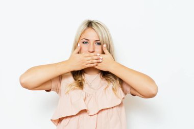 Kız gülüyor ve ağzını kapatıyor.