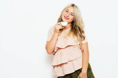 Stüdyo arka planında fincan olan kadın.