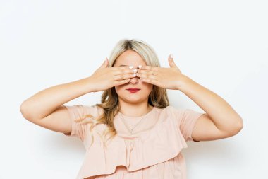 Kadın elleriyle gözlerini kapatıyor.