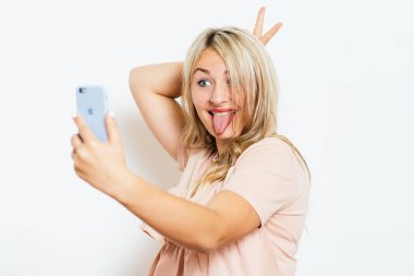 Stüdyonun arka planında selfie çeken kadın.