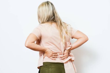 Stüdyo geçmişine karşı sırt ağrısı olan bir kadın.