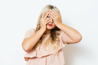 Kadın elini yüzünü kapatıyor.