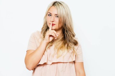 Kadın parmağını dudaklarına koydu.