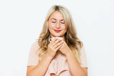 Stüdyo arka planında fincan olan kadın.