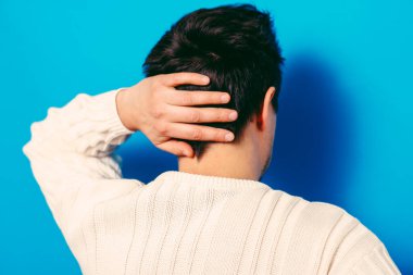 Kafasını tutarak. Arkadaki adam