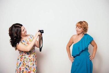 İki yetişkin kadın birbirlerinin fotoğraflarını çekiyor.