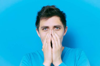 Adam gülüyor ve ağzını kapatıyor.