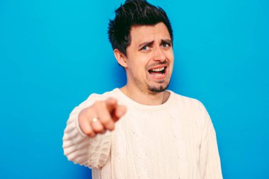 Genç adam işaret parmağını kameraya doğru gösteriyor.