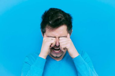 Stüdyo arka planında ağlayan adam 