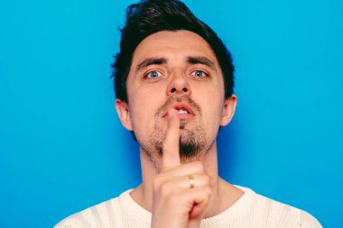 Adam parmağını onun dudaklarına koydu.