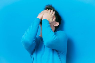 Adam elleriyle yüzünü örttü.