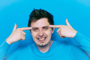 Parmağıyla şakağına dokunan öfkeli bir adamın yakın plan portresi. Delirdin mi sen??