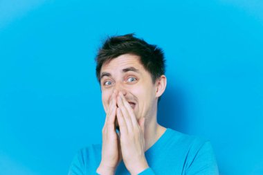 Adam gülüyor ve ağzını kapatıyor.