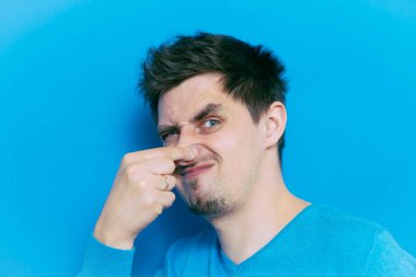 Leş gibi kokuyor. Adamın burnunu kapatır.