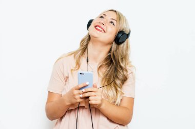 Stüdyo geçmişine karşı kulaklık takan kadın.