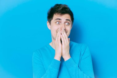 Adam gülüyor ve ağzını kapatıyor.