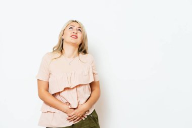 Stüdyo arka planında karın ağrısı olan kadın.