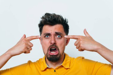 Parmağıyla şakağına dokunan öfkeli bir adamın yakın plan portresi. Delirdin mi sen??