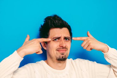 Parmağıyla şakağına dokunan öfkeli bir adamın yakın plan portresi. Delirdin mi sen??